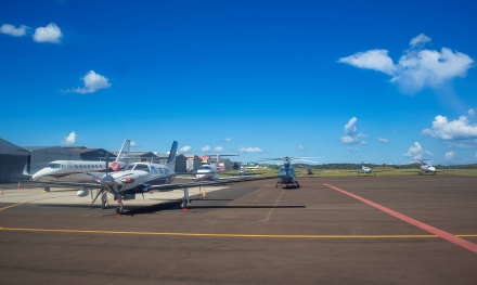 MB Comunica��o Empresarial e Organizacional - A Mercoagro 2026 � Feira Internacional de Neg�cios, Processamento e Industrializa��o da Carne � movimenta o universo da prote�na animal, a Am�rica Latina e principalmente Chapec�. Durante quatro dias de feira, o munic�pio do oeste catarinense � transformado em um polo estrat�gico que concentra empresas, lideran�as e oportunidades de neg�cios do setor. Os registros de credenciamento da feira revelam compradores e visitantes internacionais: Alemanha, Argentina, Bangladesh, Bol�via, Canad�, Chile, Col�mbia, Costa Rica, Espanha, Estados Unidos, Guatemala, Honduras, It�lia, Nova Zel�ndia, Pa�ses Baixos, Paquist�o, Paraguai, Peru, Pol�nia, Uruguai e Venezuela. Junto com o p�blico de diversas regi�es do Brasil, s�o 22 nacionalidades na feira neste ano. O porta-voz da Voe Xap e gestor do Aeroporto de Chapec�, Filipe Dias Gomes, afirma que o movimento no terminal tem sido at�pico. Segundo ele, em um dos per�odos da quarta-feira (18), o p�tio chegou a registrar 15 aeronaves ao mesmo tempo, situa��o que chamou a aten��o at� da equipe da Prefeitura de Chapec�, que esteve no local para fotografar a cena. De acordo com Gomes, a alta rotatividade das aeronaves ajuda na opera��o do aeroporto, j� que muitos empres�rios chegam, participam dos compromissos na Mercoagro e deixam a cidade em seguida, o que abre espa�o para a chegada de outros passageiros. Ele tamb�m pontuou a presen�a de duas aeronaves internacionais no aeroporto, sendo uma da Argentina e outra do Uruguai. O presidente do Sindicato dos Hot�is, Restaurantes, Bares e Similares de Chapec� (Sihrbasc), Gustavo Gisi, salienta que a Mercoagro �, de forma disparada, a feira que mais gera movimenta��o econ�mica em todo o trade tur�stico do munic�pio. �O evento registra a maior procura da rede hoteleira e tamb�m uma demanda mais exigente, impulsionada principalmente por um p�blico executivo e de alto padr�o�, observa. De acordo com Gisi, em compara��o com outras feiras realizadas em Chapec�, a Mercoagro apresenta uma procura superior. Mesmo com a rede hoteleira totalmente ocupada durante os dias do evento, outras modalidades de hospedagem, como apartamentos e casas em plataformas de loca��o, tamb�m tiveram alta demanda no per�odo. �Como a feira ocorre ao longo de quatro dias, o impacto se estende por praticamente uma semana inteira, mantendo os hot�is com elevada ocupa��o e garantindo um grande giro de visitantes. Al�m disso, muitas empresas mant�m equipes na cidade desde a segunda-feira at� o s�bado, o que amplia ainda mais a circula��o de recursos na economia local�, detalha. Segundo o dirigente, esse fluxo beneficia todo o trade tur�stico e diversos setores da cidade. Al�m da movimenta��o no aeroporto, tamb�m h� reflexos em servi�os como t�xis, transporte por aplicativo, supermercados, sal�es de beleza e no com�rcio em geral. Gisi ressalta, ainda, a demanda gerada na prepara��o e no suporte � feira. �O atendimento aos expositores, a montagem dos estandes e a compra de equipamentos e materiais nos �ltimos dias tamb�m contribuem para aquecer a economia o que amplia os efeitos positivos do evento para Chapec�, afirma.